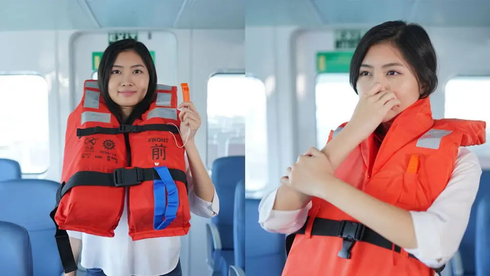 A person demonstrates the use of an orange life vest in two side-by-side images, presented like an animation. On the left, they hold a whistle attached to the vest. On the right, they pinch their nose and prepare to inflate the vest. Both scenes are set inside a boat's interior.