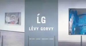 Inside the art gallery, a large grey divider displays "LG LÉVY GORVY" with the cities "New York," "London," "Hong Kong," and "Zurich" listed below. To the left, a painting graces the wall. The space is primed for an elegant promotional video highlighting fine art.
