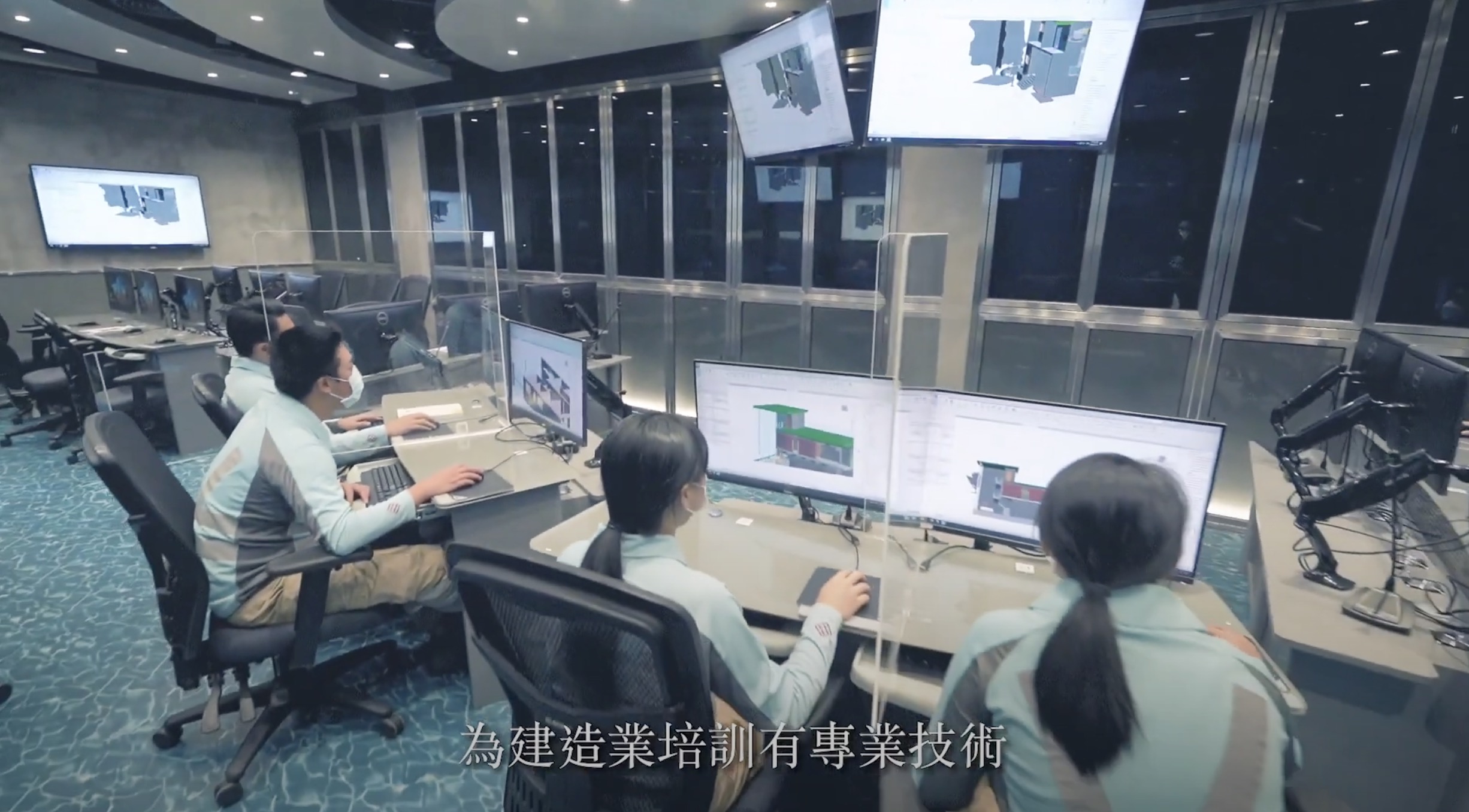 Four people wearing masks sit at desks with multiple monitors in a modern control room. Large screens display technical diagrams. Chinese text is overlaid at the bottom of the image.