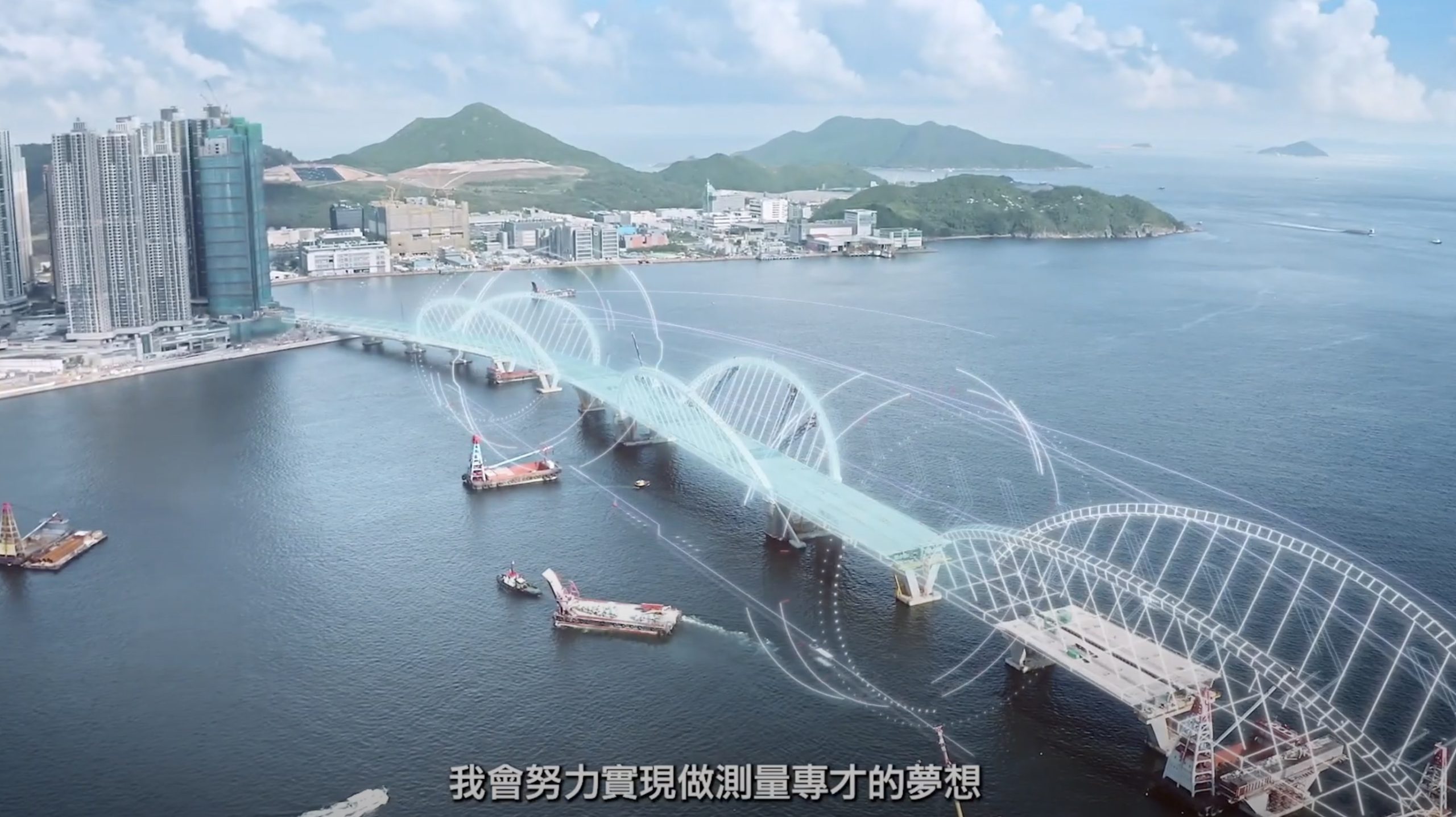 A partially constructed bridge stretches over blue water, with digital overlays illustrating its planned design. Buildings, hills, and islands are visible in the background. Subtitles in Chinese appear at the bottom of the image.