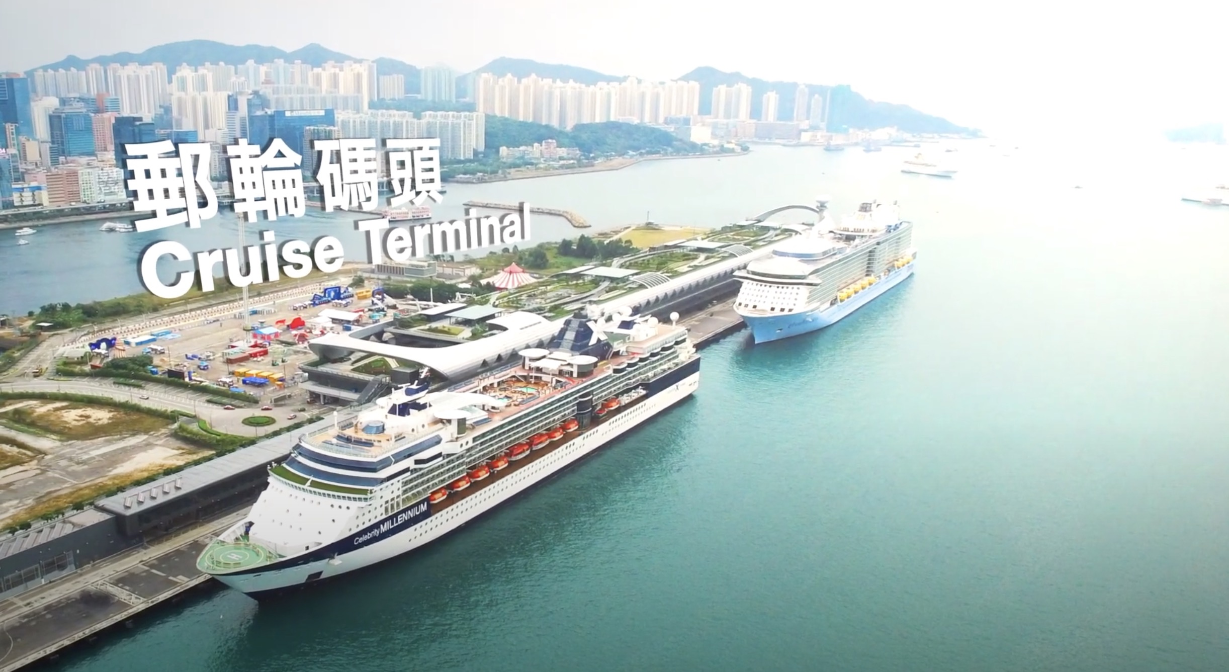 Aerial view of a cruise terminal with two large cruise ships docked, modern buildings nearby, and a city skyline with numerous high-rise buildings in the background. Text reads "Cruise Terminal" in English and Chinese.
