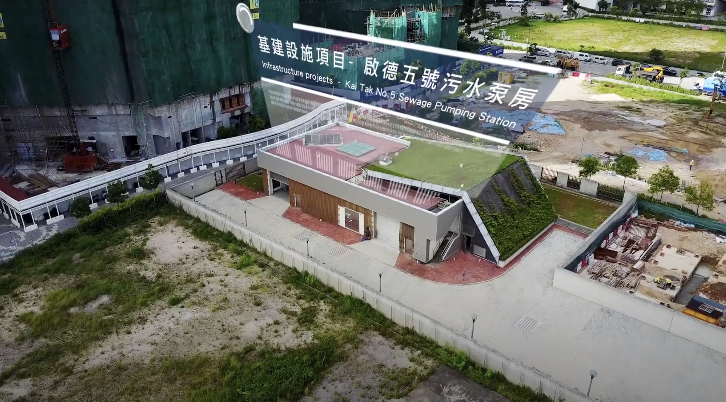 Aerial view of the Kai Tak No. 5 Sewage Pumping Station, featuring a modern building with a green roof and a fenced perimeter, next to a large sign in Chinese and English and nearby construction areas.