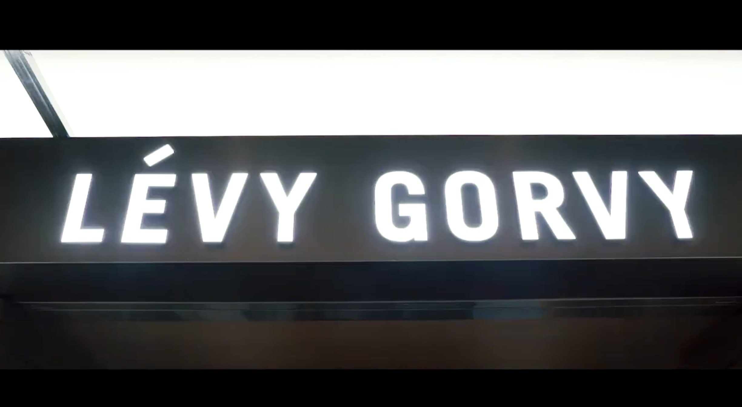 Illuminated sign displaying the name “LÉVY GORVY” in bold, white capital letters on a dark background.