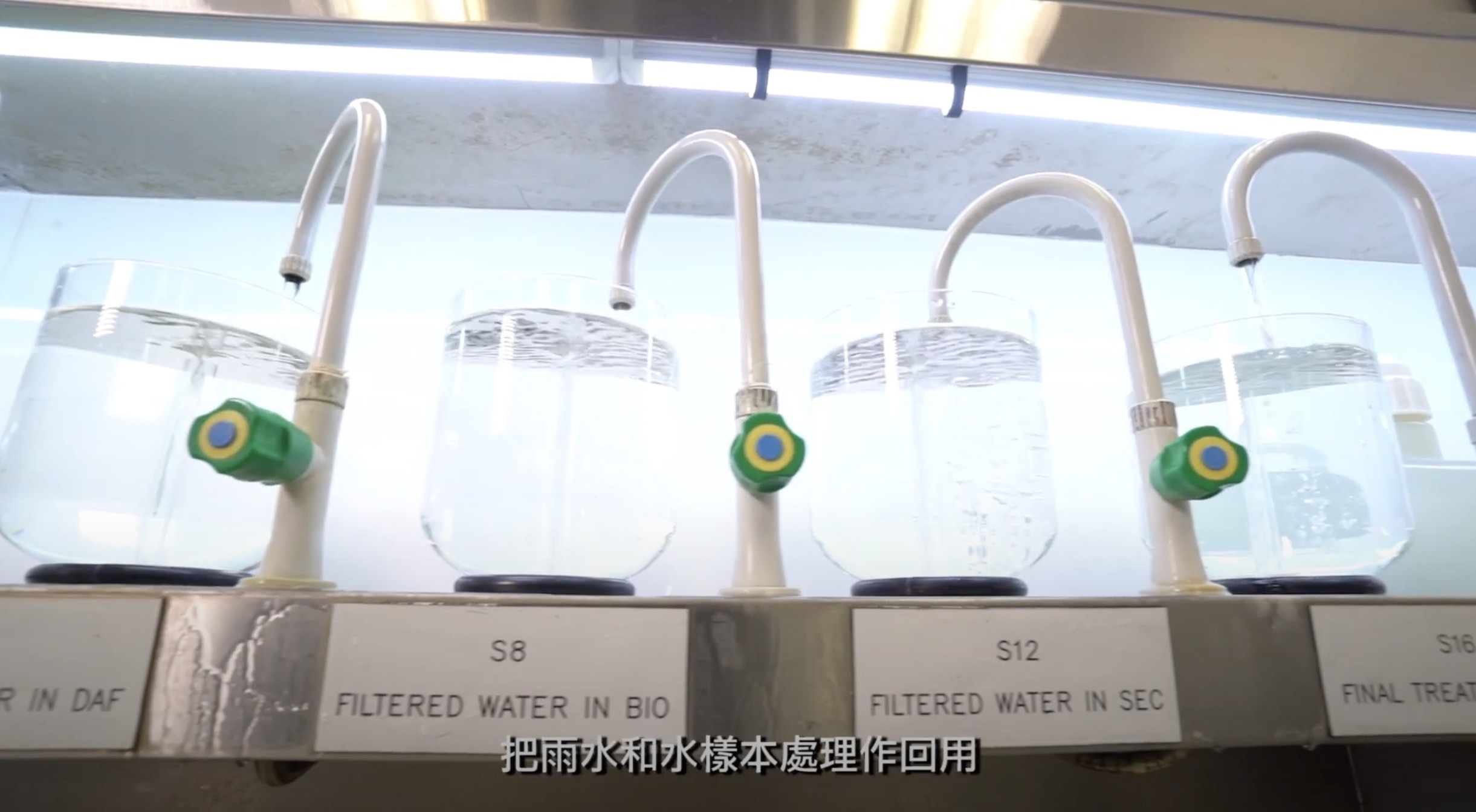 Four clear containers, each labeled for a filtration stage (S8, S12, S16), are lined up under a light, with water flowing through white pipes; Chinese subtitles appear at the bottom.