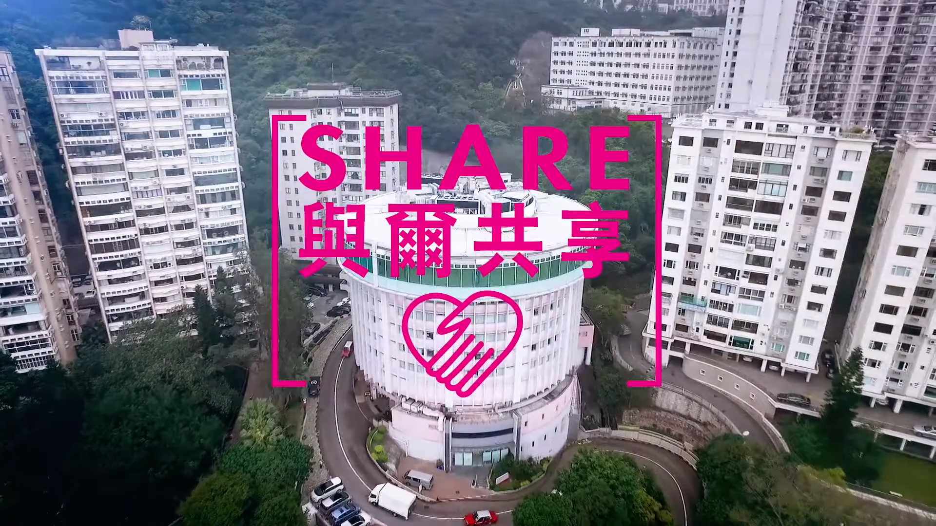 Aerial view of a round building surrounded by tall apartment blocks and greenery, with pink text overlay reading "SHARE" and Chinese characters, above a hand and heart icon.