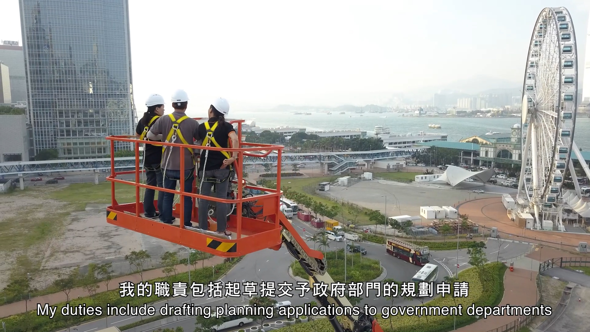 Three construction workers in safety gear stand on an elevated platform, overlooking a cityscape with a Ferris wheel and waterfront in the background. Subtitles describe their duties in English and Chinese.