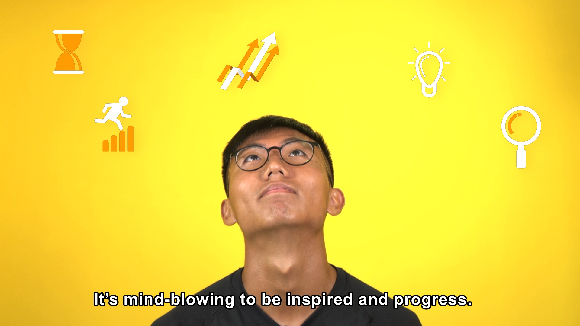 A young man with glasses looks up thoughtfully against a bright yellow background with icons of growth, ideas, achievement, and discovery. The caption reads, "It's mind-blowing to be inspired and progress.