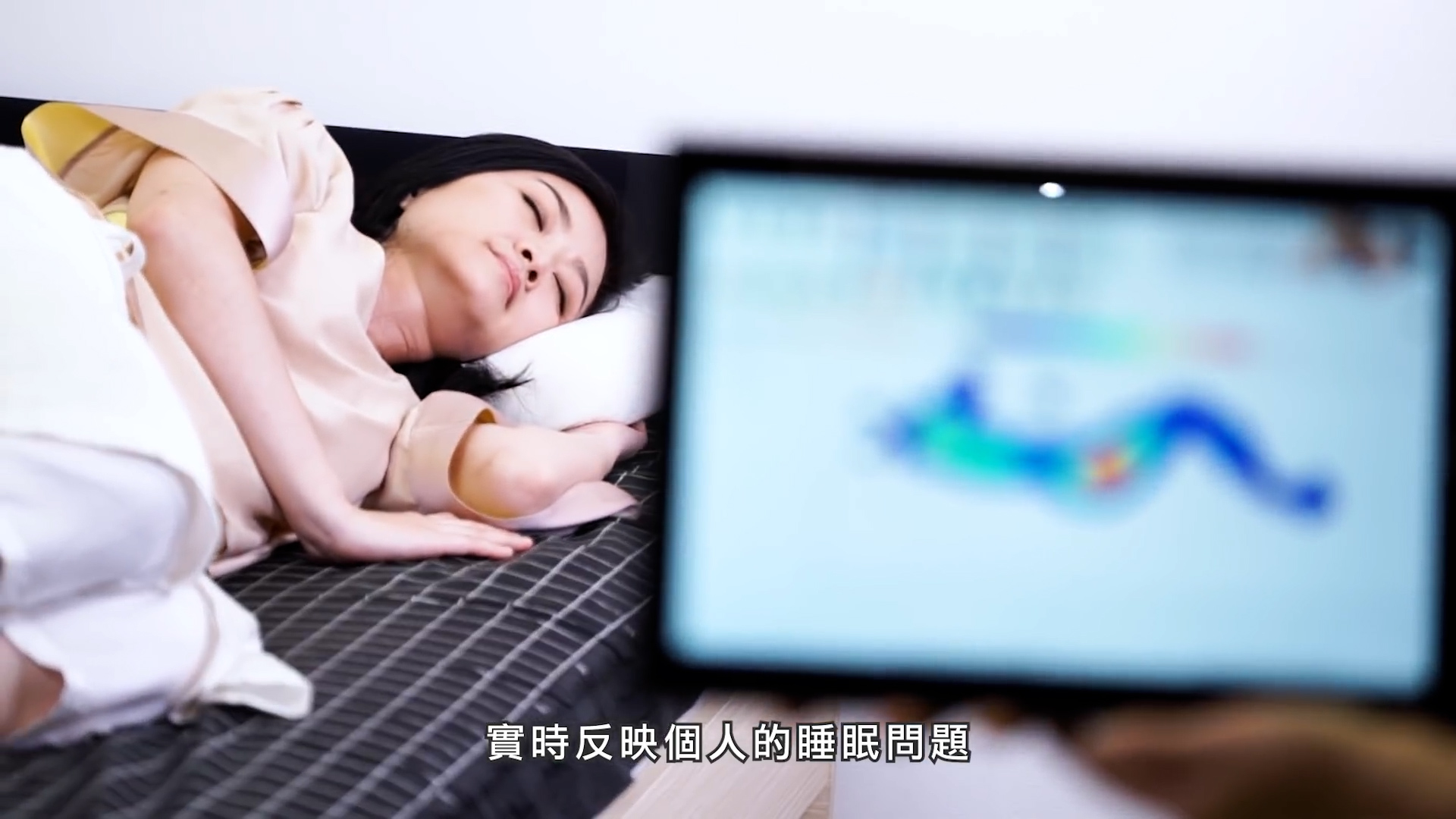 A woman lies on a bed looking thoughtful while a blurred screen is held in the foreground. Chinese subtitles are displayed at the bottom of the image.