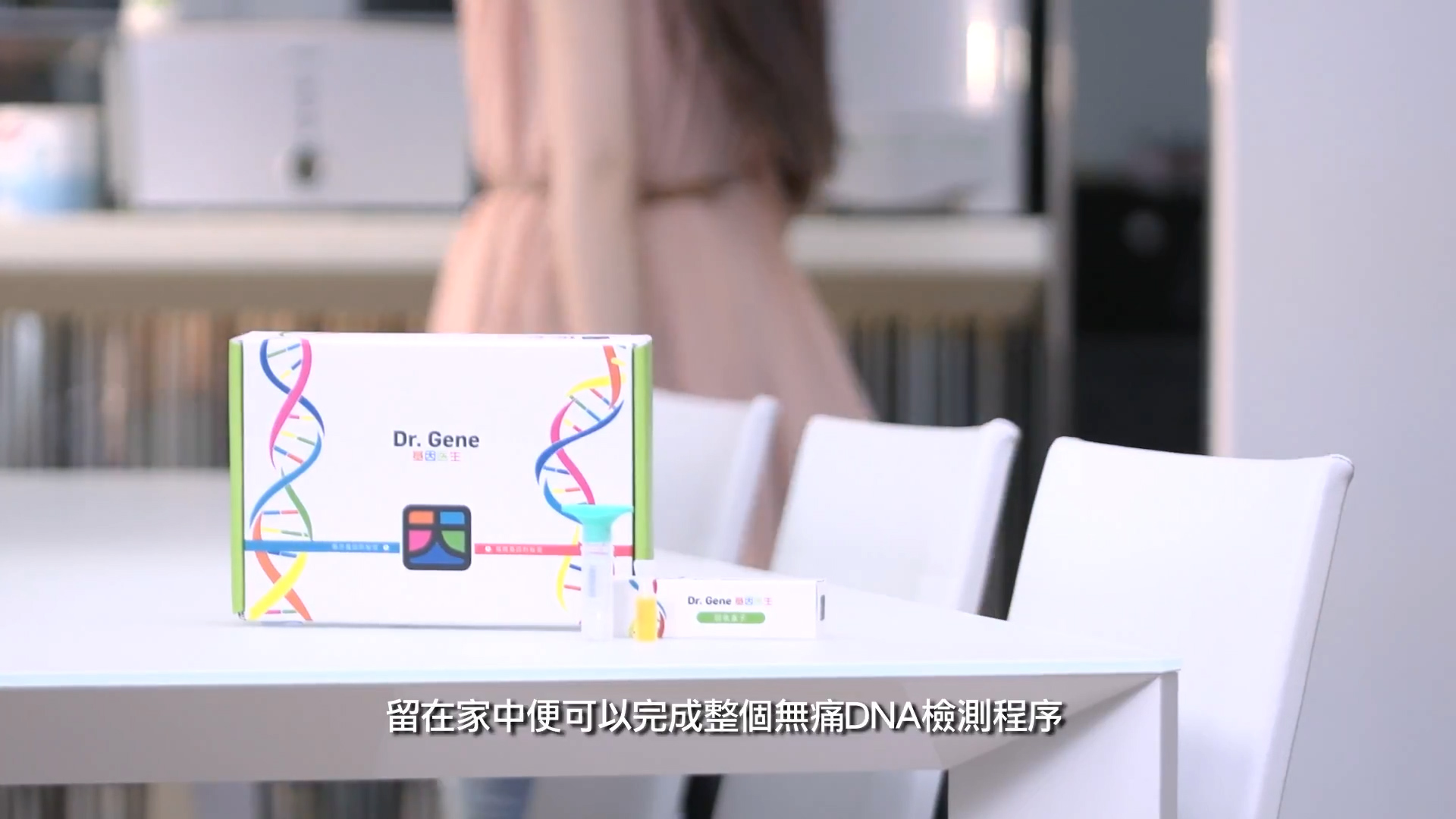 A DNA test kit labeled "Dr. Gene" sits on a white table with a tube beside it; a person stands in the background near a kitchen, and Chinese subtitles appear at the bottom of the image.