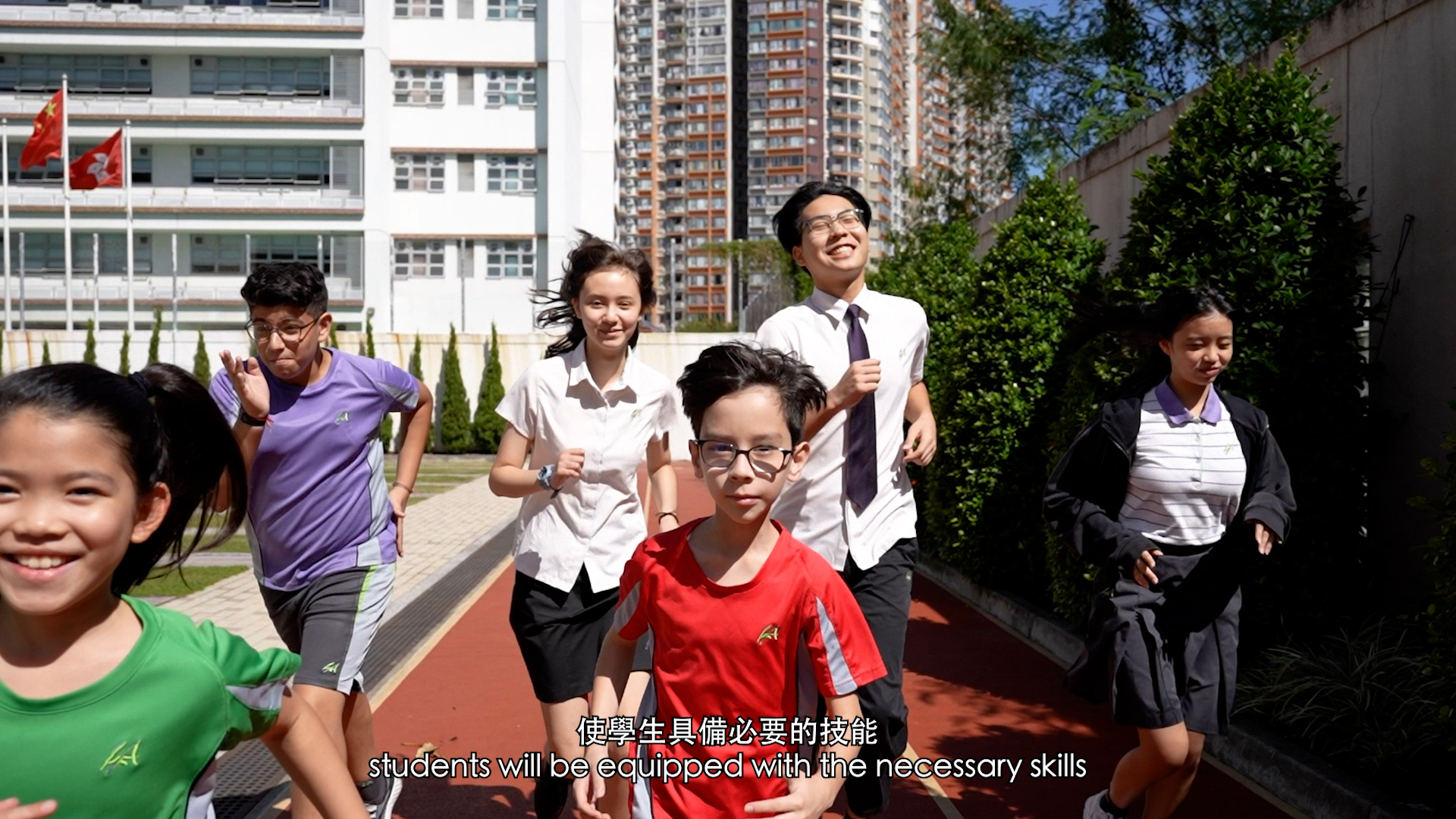 A group of students in school uniforms and sportswear run and smile outdoors on a school track, with buildings and trees in the background. Text at the bottom reads, “students will be equipped with the necessary skills.”.