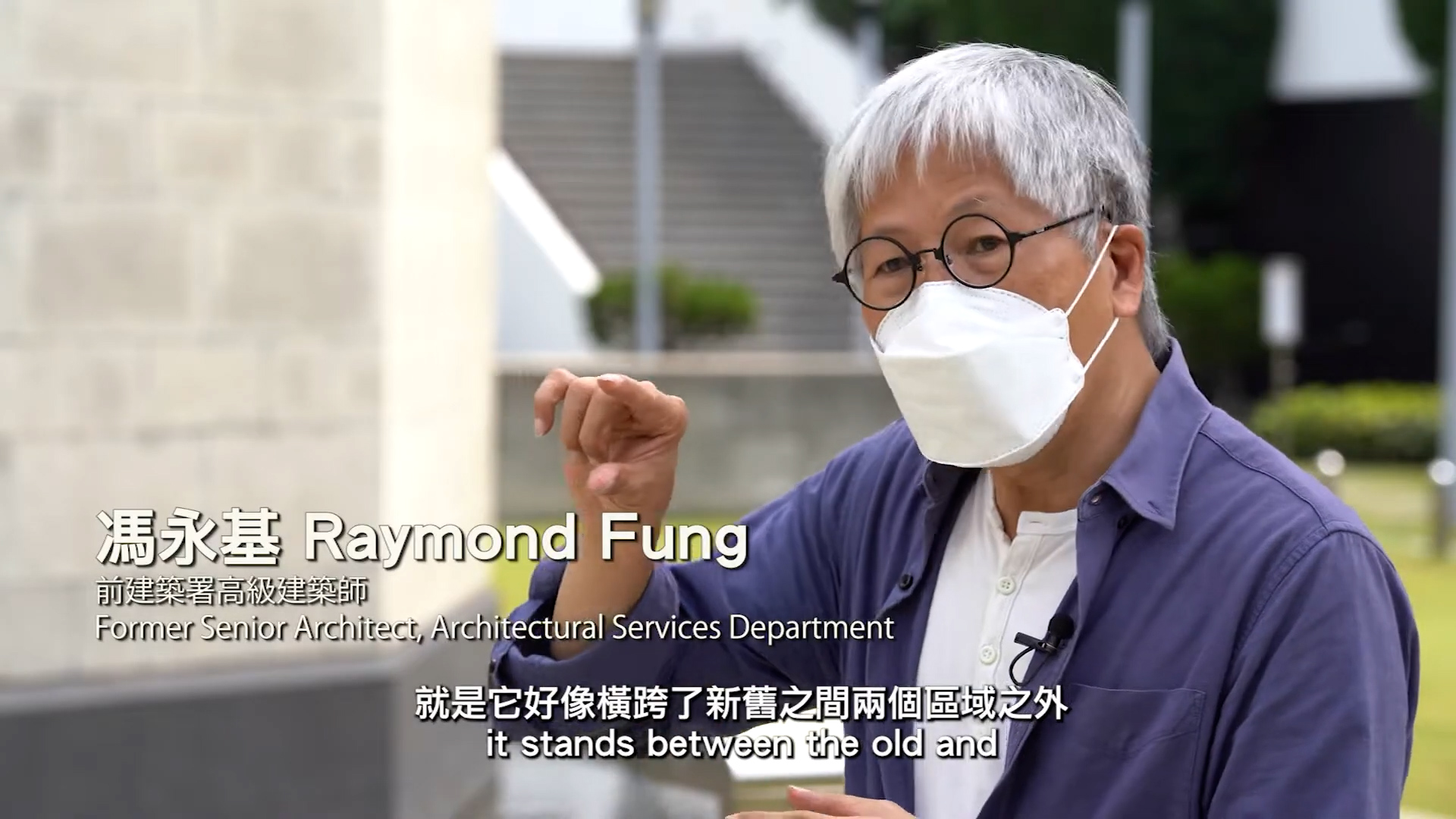 An older man with gray hair, glasses, and a white face mask gestures with his hand while speaking outdoors. On-screen text identifies him as Raymond Fung, a former senior architect, with English and Chinese subtitles.