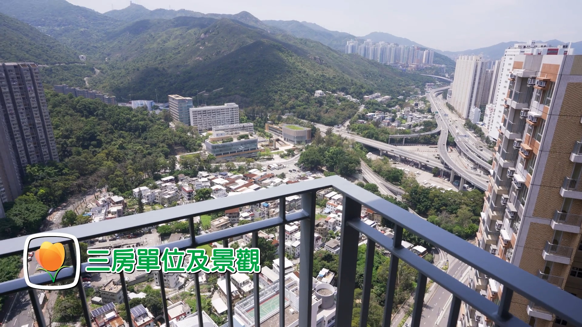 View from a high balcony overlooking a cityscape, green hills, highways, and clusters of buildings. Text in Chinese appears on the bottom left, next to a peach icon.