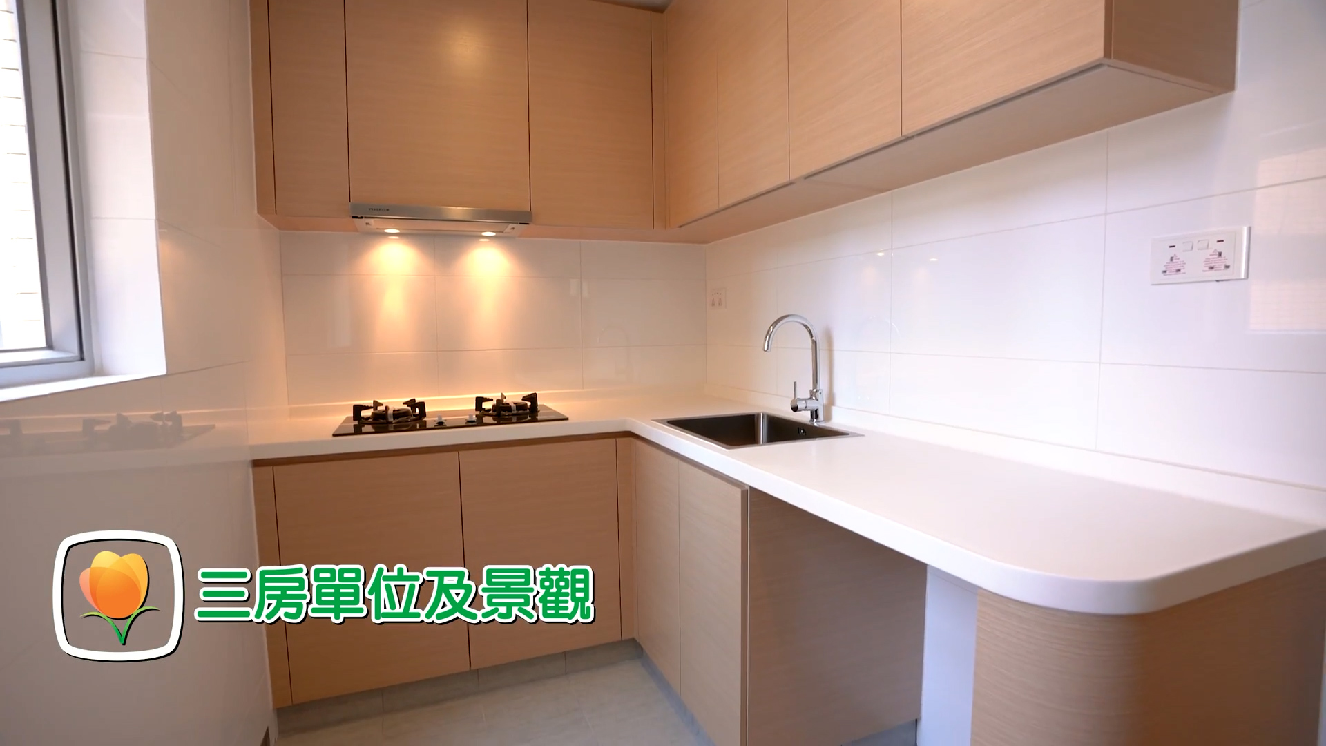 A modern kitchen with light wood cabinets, a gas stove, and a sink under bright lighting. Chinese text and a flower icon are overlaid in the lower left corner.