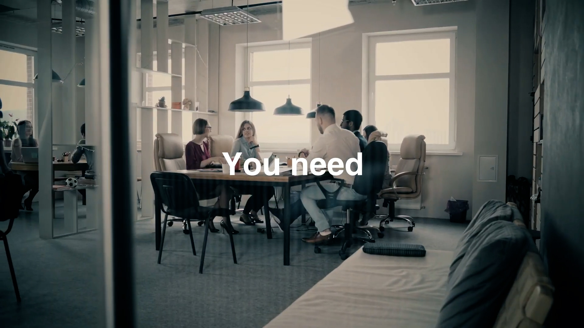 A group of people sit around a table having a meeting in a modern office with large windows. The words "You need" are centered over the image in white text.