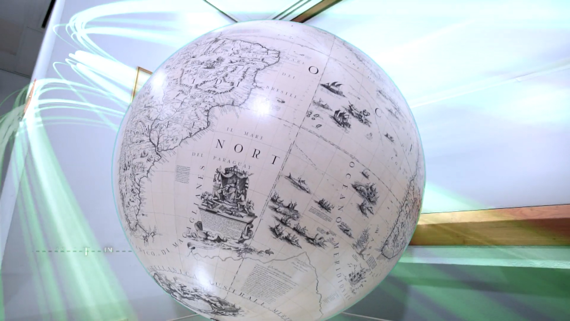 A large, detailed antique-style globe displaying parts of South America and the Atlantic Ocean is suspended indoors, with light streaks and reflections creating a dynamic effect around it.