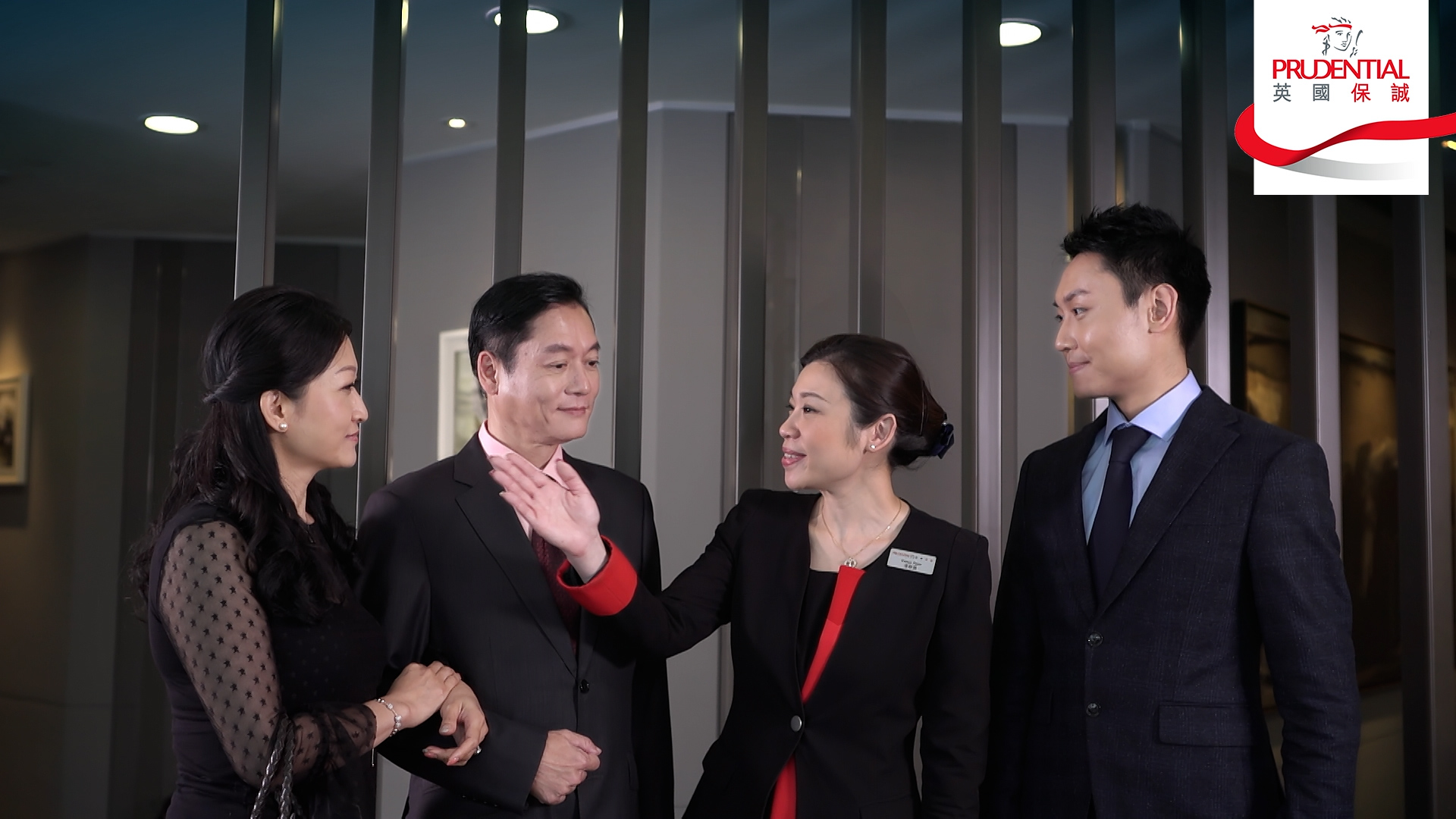 Four professionally dressed people, three women and one man, are standing and conversing in an office setting. The Prudential logo is displayed in the top right corner of the image.