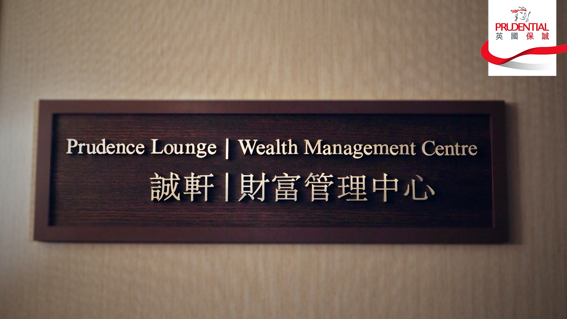 A sign on a wall reads “Prudence Lounge | Wealth Management Centre” in English and Chinese. The Prudential logo appears in the top right corner.