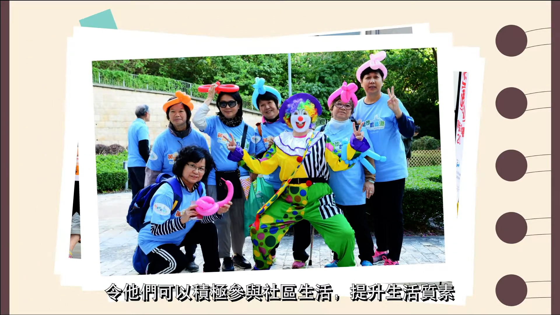 A group of people wearing light blue shirts and colorful balloon hats pose outdoors with a person dressed as a clown. Chinese text is displayed at the bottom of the image.