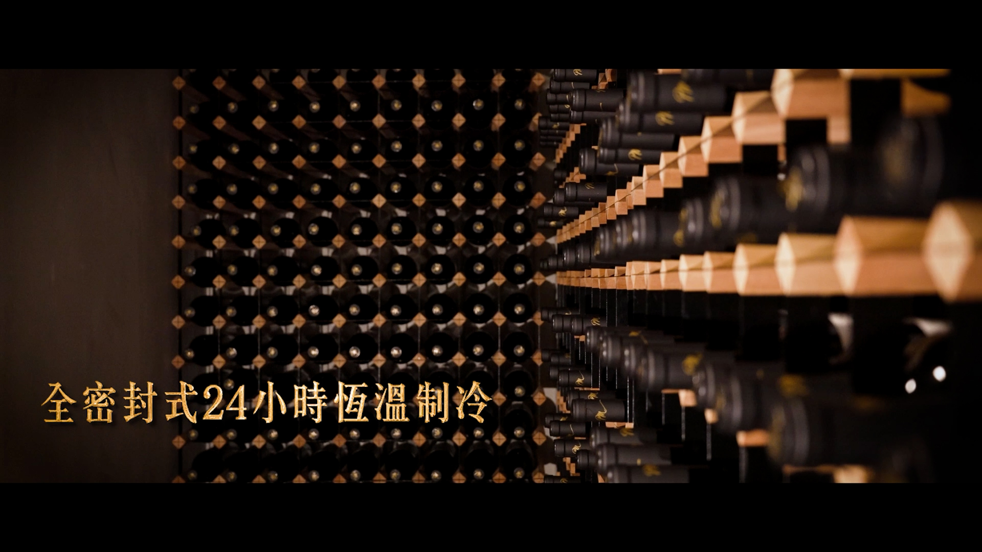 A wall of wine bottles stored horizontally on wooden racks, viewed from an angle. Chinese text in gold at the bottom left reads "全密封式24小時恆溫制冷," which means "Fully sealed, 24-hour constant temperature refrigeration.