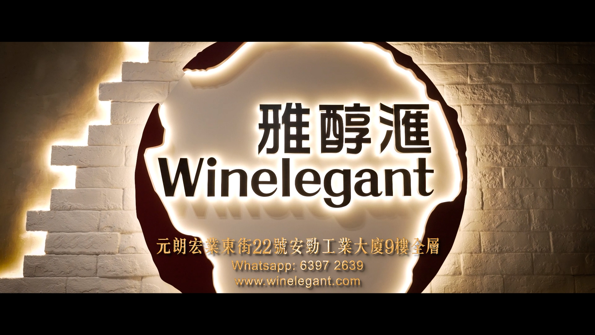 A backlit sign on a brick wall displays the Winelegant logo with Chinese characters above, and address, WhatsApp number, and website below in both Chinese and English.