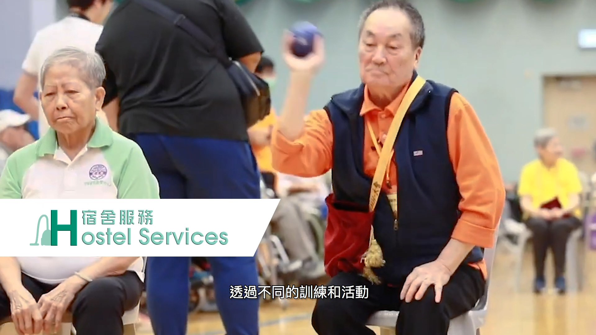 Two elderly people sit indoors; one man in an orange shirt is throwing a ball, while another woman in green sits beside him. The words “Hostel Services” and Chinese text appear on the image.